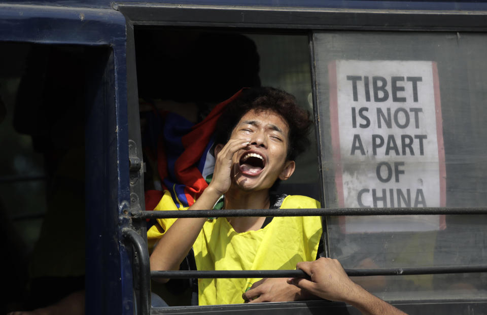 FILE - In this Wednesday, Oct. 18, 2017, file photo, an exile Tibetan shouts slogans while being taken away in a police vehicle after a protest near the Chinese embassy in New Delhi, India. Chinese President Xi Jinping is coming to India to meet with Prime Minister Narendra Modi on Friday, Oct. 11, 2019, just weeks after Beijing supported India's rival Pakistan in raising the issue of New Delhi's recent actions in disputed Kashmir at the U.N. General Assembly meeting. Tibet's exiled spiritual leader the Dalai Lama has lived in India since fleeing there amid an abortive uprising against Chinese rule in 1959. (AP Photo/Manish Swarup, File)