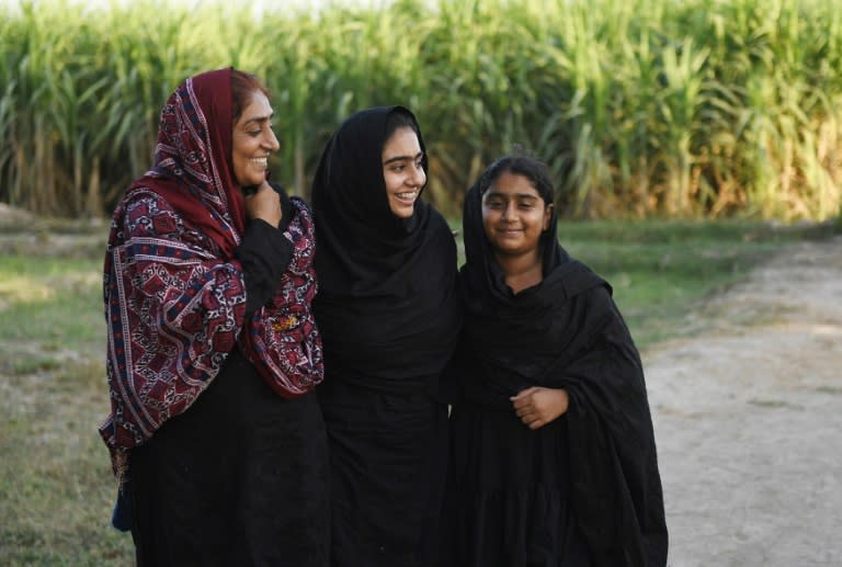 Pakistani woman Mukhtiar Naz (L), known as Waderi Nazo Dharejo, with her daughters at her agriculture field in Qazi Ahmed in Sindh province