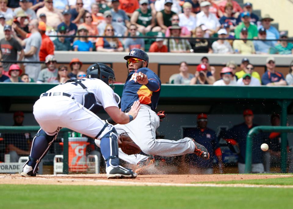 Mar 8, 2015; Lakeland, FL, USA; Houston Astros first baseman Jon Singleton (21) slides save into home plate to score a run as Detroit Tigers catcher James McCann (34) attempted to tag him out at a spring training baseball game at Joker Marchant Stadium.