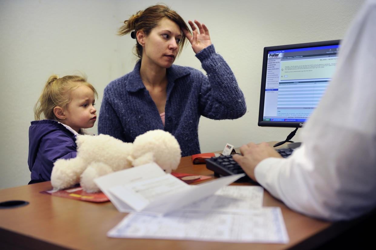 Melissa Fitzpatrick and her 4 year old daughter Rory watch as her refund is totaled at Jackson Hewitt Tax Service in Wheat Ridge. Joe Amon, The Denver Post  (Photo By Joe Amon/The Denver Post via Getty Images)