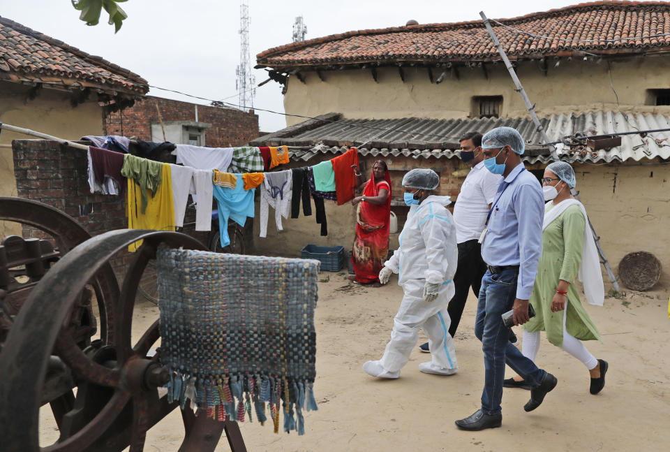 Health workers arrive to test villagers for COVID-19 and to persuade them get vaccinated at Sikanderpur village, Uttar Pradesh state, India, on June 9, 2021. India's vaccination efforts are being undermined by widespread hesitancy and fear of the jabs, fueled by misinformation and mistrust. That's especially true in rural India, where two-thirds of the country’s nearly 1.4 billion people live. (AP Photo/Rajesh Kumar Singh)