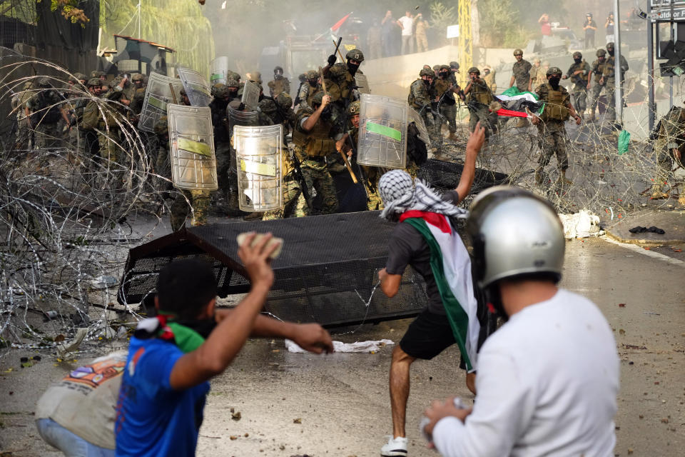 Protesters throw stones towards Lebanese army during a demonstration in solidarity with the Palestinian people in Gaza, near the U.S. embassy in Aukar, a northern suburb of Beirut, Lebanon, Wednesday, Oct. 18, 2023. (AP Photo/Hassan Ammar)