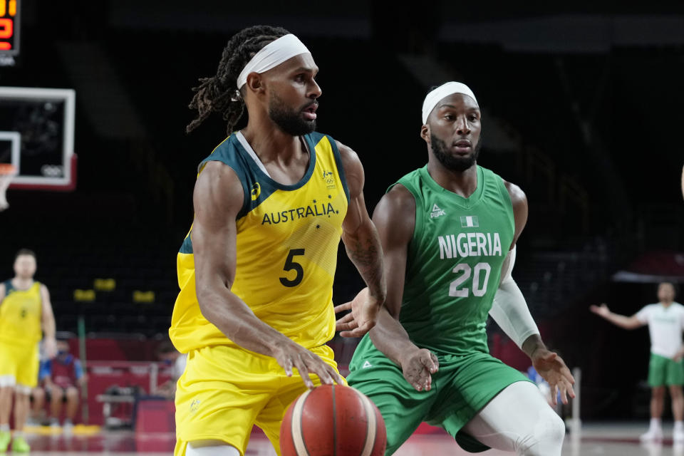 Australia's Patty Mills (5) drives around Nigeria's Josh Okogie (20) during a men's basketball preliminary round game at the 2020 Summer Olympics, Sunday, July 25, 2021, in Saitama, Japan. (AP Photo/Eric Gay)