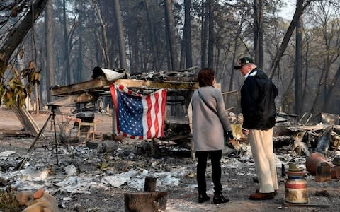 Donald Trump views the charred remains left behind after wildfires swept through Paradise, California - Credit: Saul Loeb/AFP