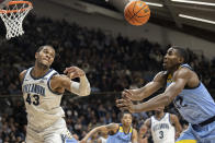 Villanova forward Eric Dixon (43) and Marquette guard Darryl Morsell (32) chase a rebound during the second half of an NCAA college basketball game, Wednesday, Jan. 19, 2022, in Villanova, Pa. (AP Photo/Laurence Kesterson)