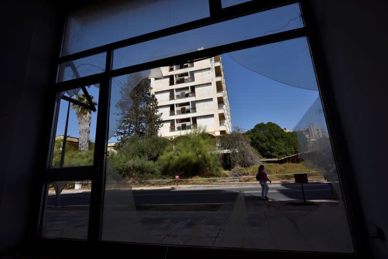 A woman walks in the abandoned coastal area of Varosha