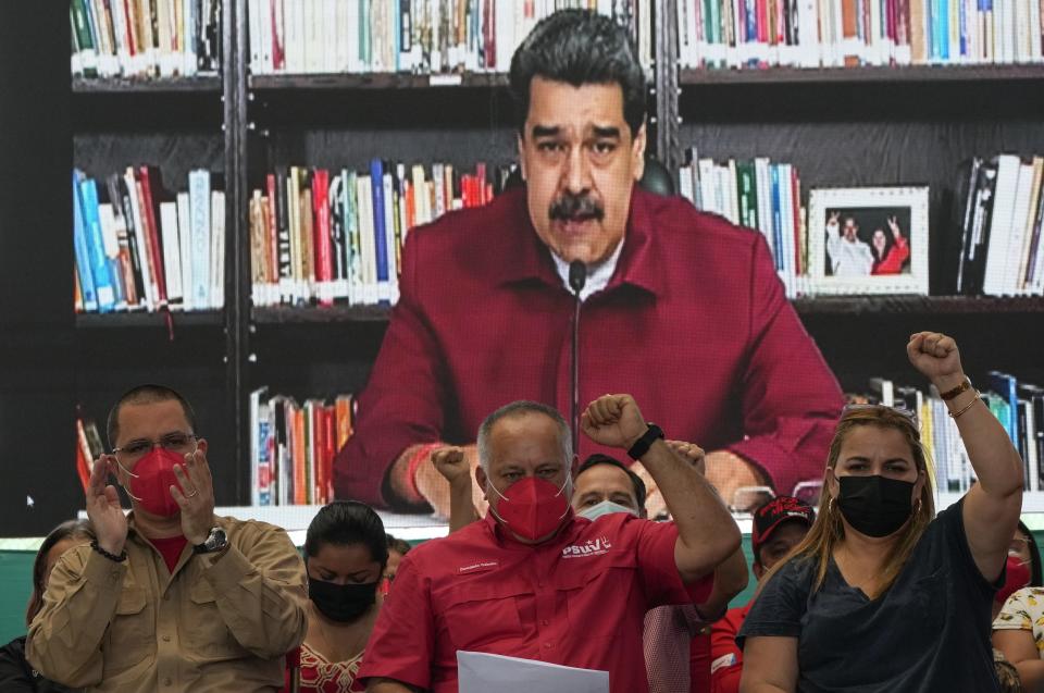 Former foreign Minister Jorge Arreaza, left, socialist party leader Diosdado Cabbello, center, and ruling party lawmaker Irirs Varela cheers as Venezuela's President Nicolas Maduro speaks via a livestream in Barinas, Venezuela, Sunday, Dic 5, 2021. Maduro named Arreaza as the ruling party's candidate to the gubernatorial race for Barinas state. The announcement came less than a week after the country's highest court disqualified opposition candidate Freddy Superlano for the governorship of Barinas as he was leading the vote count, a move that has become emblematic of what the opposition says are unfair election conditions. (AP Photo/Ariana Cubillos)