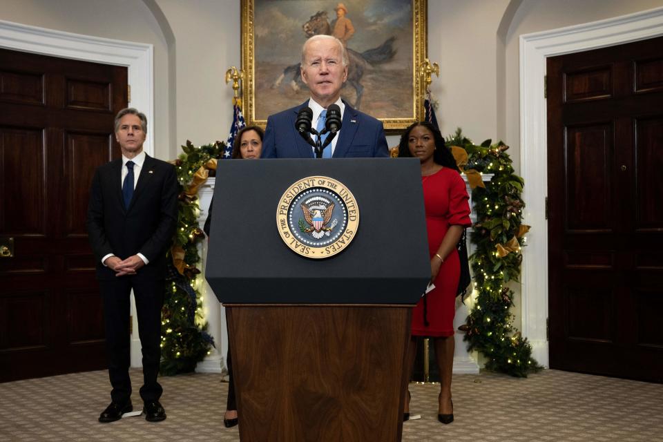 President Biden stands at a podium with a presidential seal in front of Antony Blinken, Kamala Harris and Cherelle Griner.