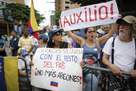 People protest a day after a massive blackout as they gather for a rally called by opposition leader and self-proclaimed interim president of Venezuela Juan Guaido, in Caracas, Venezuela, Tuesday, July 23, 2019. The lights were returning to life early Tuesday across Venezuela following a massive blackout a day earlier that crippled communications, froze the Caracas metro and snarled rush hour traffic, officials said. (AP Photo/Ariana Cubillos)