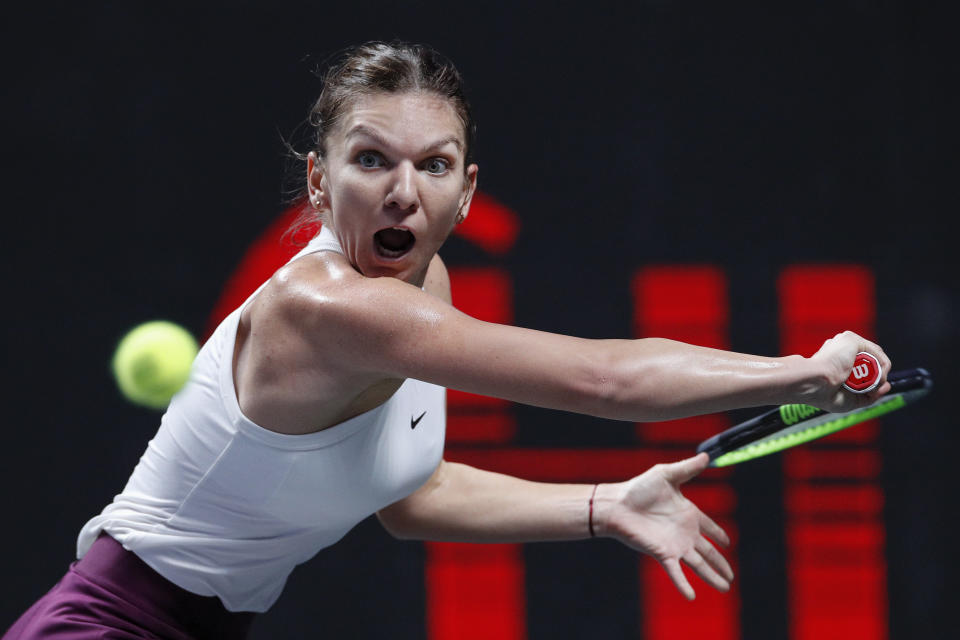 FILE - In this Oct. 28, 2019, file photo, Simona Halep, of Romani, eyes on the ball as she plays against Bianca Andreescu, of Canada, during their WTA Finals Tennis Tournament in Shenzhen, China's Guangdong province. Halep will be competing in the Australian Open tennis tournament, beginning Monday, Jan. 20, 2020. (AP Photo/Andy Wong, File)