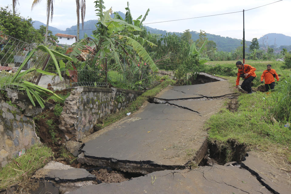 Rescuers navigate through a road badly damaged during Monday's earthquake, in Cianjur, West Java, Indonesia, Wednesday, Nov. 23, 2022. More rescuers and volunteers were deployed Wednesday in devastated areas on Indonesia's main island of Java to search for the dead and missing from an earthquake that killed hundreds of people. (AP Photo/Rangga Firmansyah)