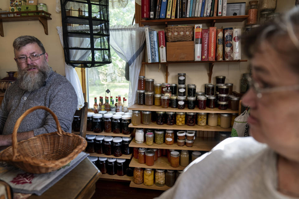 Jars of food sit on the shelves of Mark, left, and Linda Carlson's kitchen in Hammond, Wis., Wednesday, Sept. 28, 2022. Mark's boundless curiosity about the world often emerges in the kitchen, where he makes everything from organic yogurt to Filipino-style spring rolls to Japanese-style fried chicken cutlets. The jars and additional food they keep in storage are also part of their plan should things go really bad for America. (AP Photo/David Goldman)