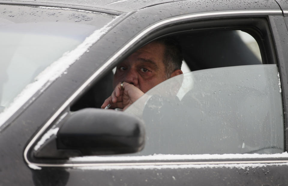 A man finishes his cigarette before a visitation for Vito Rizzuto in Montreal