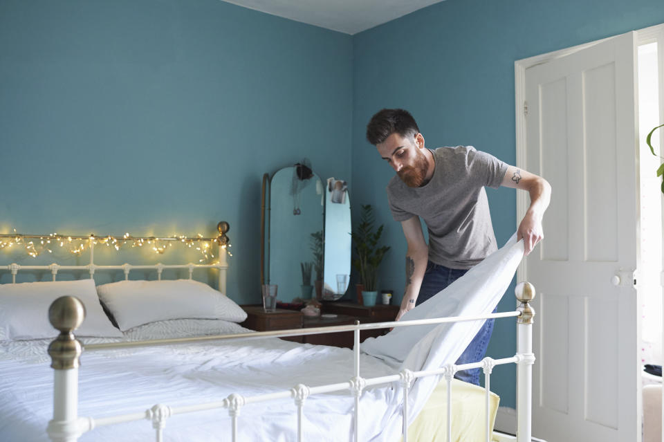 Man making bed. (Getty Images)