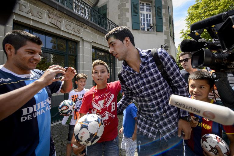 Barcelona's Uruguayan forward Luis Suarez is surrounded by fans after he pleaded his case before the Court of Arbitration for Sport (CAS) to halve his four-month FIFA ban for biting on August 8, 2014 in Lausanne