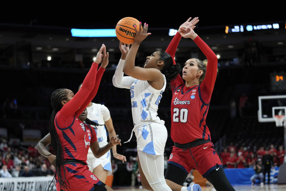 North Carolina guard Deja Kelly (25) shoots the winning basket between St. John's guard Mimi Reid (2) and Rayven Peeples (20) in the second half of a first-round women's college basketball game in the NCAA Tournament Saturday, March 18, 2023, in Columbus, Ohio. North Carolina won 61-59. (AP Photo/Paul Sancya)