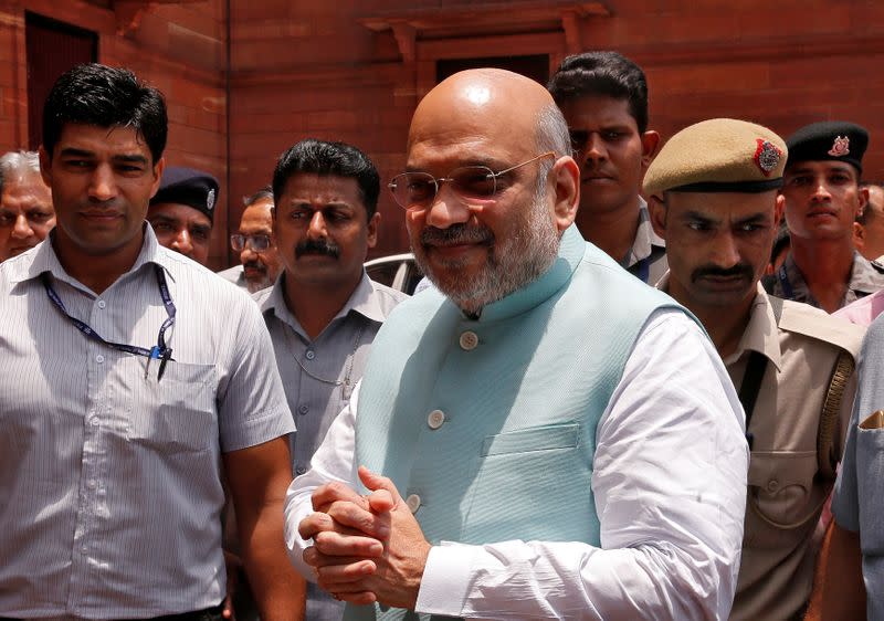 India's newly appointed Home Minister Amit Shah greets the media upon his arrival at the home ministry in New Delhi