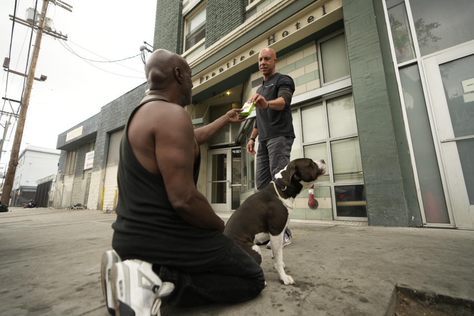 Dr. Kwane Stewart provides free medication for Big Mike's dog in the Skid Row area of Los Angeles on Wednesday, June 7, 2023. Stewart founded Project Street Vet, a nonprofit dedicated to helping as many homeless pets as possible. he funded the group himself for years, saving a chunk of his pay check before gaining sponsors and donors. (AP Photo/Damian Dovarganes)