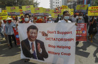 Demonstrators display a picture of Chinese president Xi Jinping, with a message requesting not to support military coup during a protest against the military coup in Mandalay, Myanmar on Wednesday, Feb. 17, 2021. Some protesters have accused Beijing — which has long been Myanmar’s main arms supplier and has major investments in the country — of propping up the junta.(AP Photo)