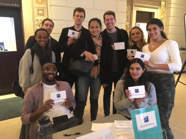 Andrea Sahouri, right, and fellow Columbia University students in a Reporting class show the fruits of their postcard-writing campaign in December 2018 to send messages of support to imprisoned journalists around the world.