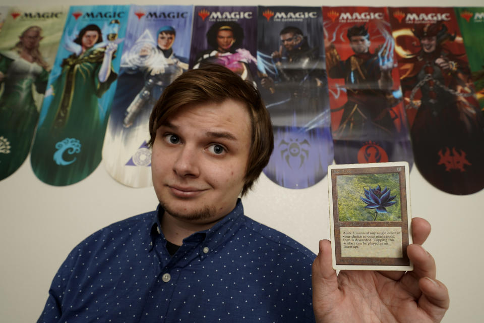 Austin Deceder, displays a Black Lotus Magic card in his home office Friday, Aug. 27, 2021, in Kansas City, Mo. Prices of the collectable cards and vintage video games that Deceder and others buy and sell have skyrocketed in the past few months to the dismay of hobbyists. (AP Photo/Charlie Riedel)