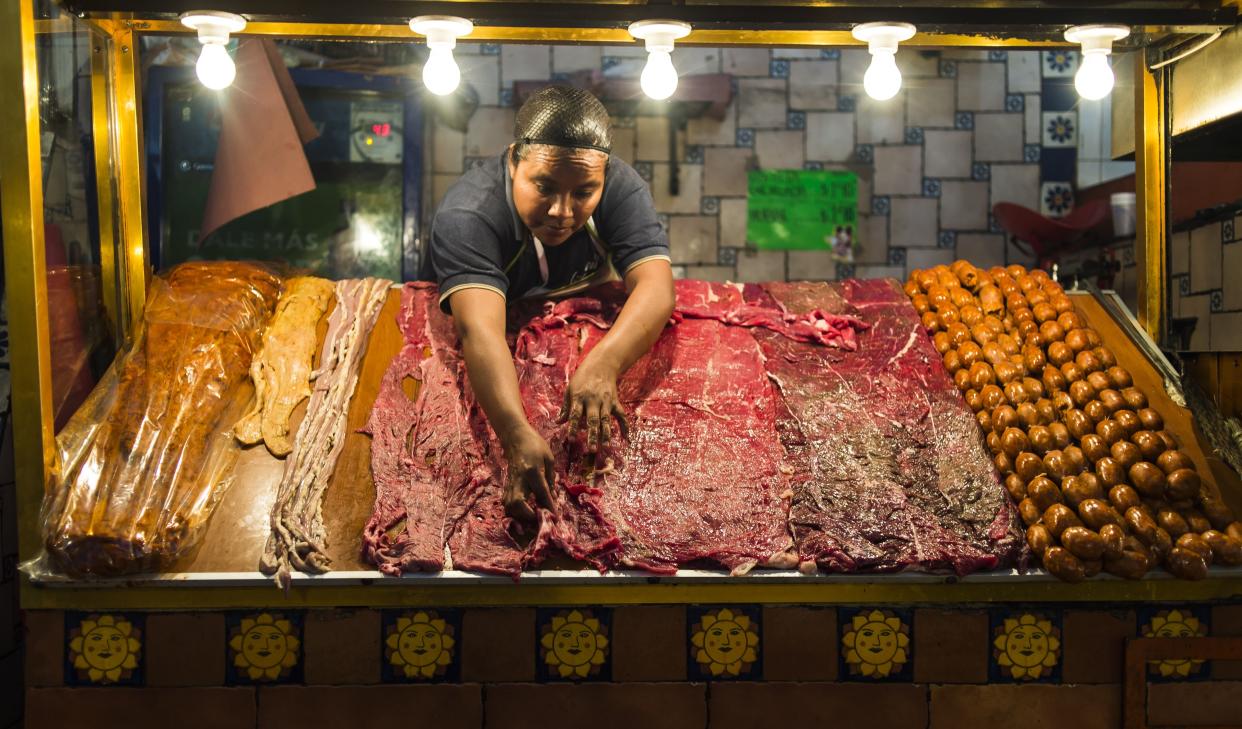 (FILES) In this file photo taken on July 29, 2014, a vendor places meat and sausages at the food zone of Oaxaca's market, in Oaxaca, Mexico.  Traditional and modern chefs of Oaxaca go to markets to find the best ingredients to prepare plates of the iconic traditional Mexican cuisine.  / AFP PHOTO / Omar TORRES / TO GO WITH AFP STORY by Jean Luis ARCE / More pictures in AFP FORUM        (Photo credit should read OMAR TORRES/AFP/Getty Images)