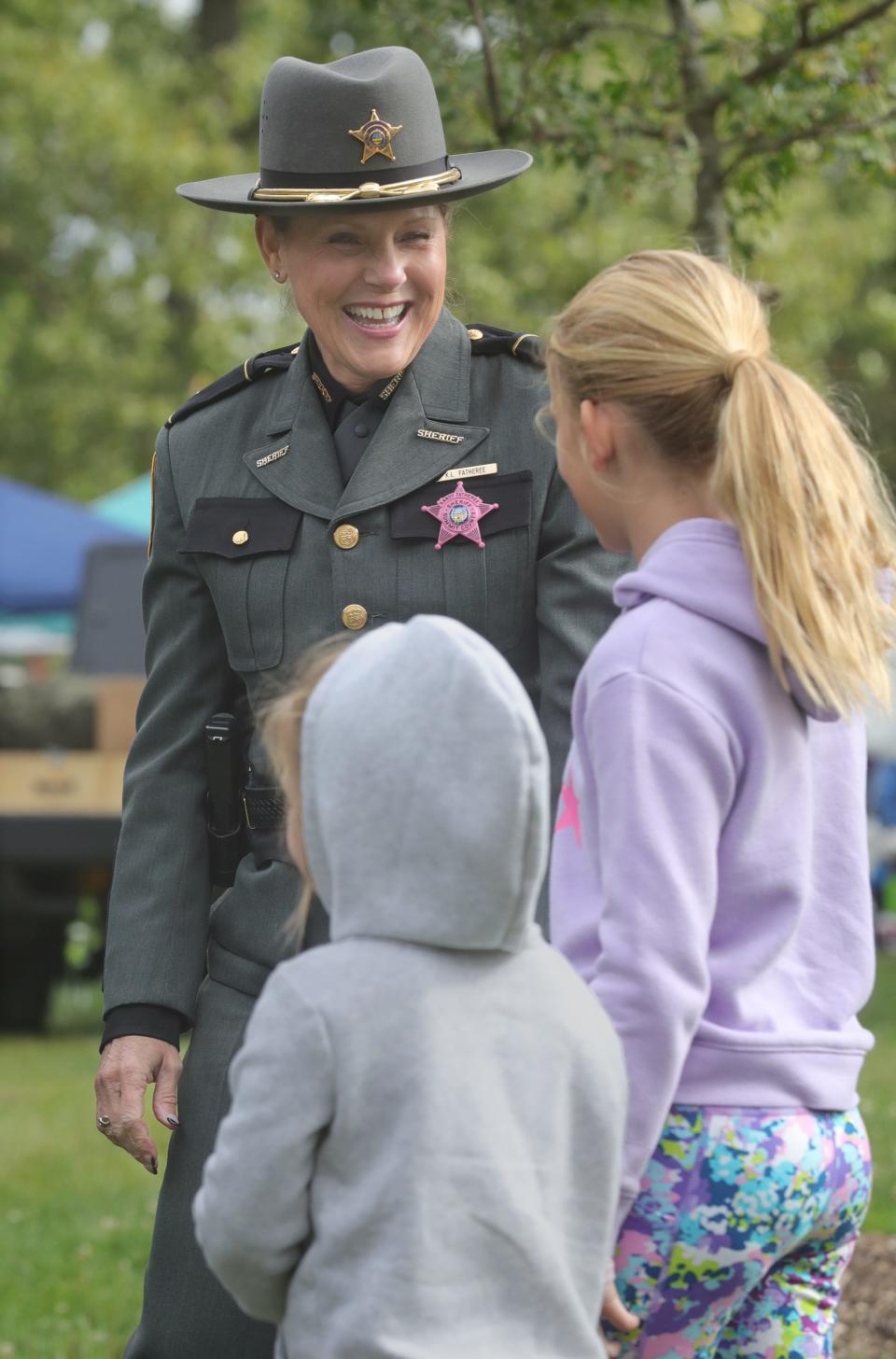 Summit County Sheriff Kandy Fatheree talks with Lennon Wiltrout, 4, and Raelyn Suggett, 9, during the Faith & Blue event on Saturday in Akron at Hardest Park.