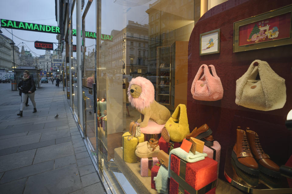 A woman walks by closed shops, in Vienna, Austria, Monday, Nov. 22, 2021. Austria went into a nationwide lockdown early Monday to combat soaring coronavirus infections, a step being closely watched by other European governments struggling with national outbreaks that are straining health care systems.(AP Photo/Vadim Ghirda)