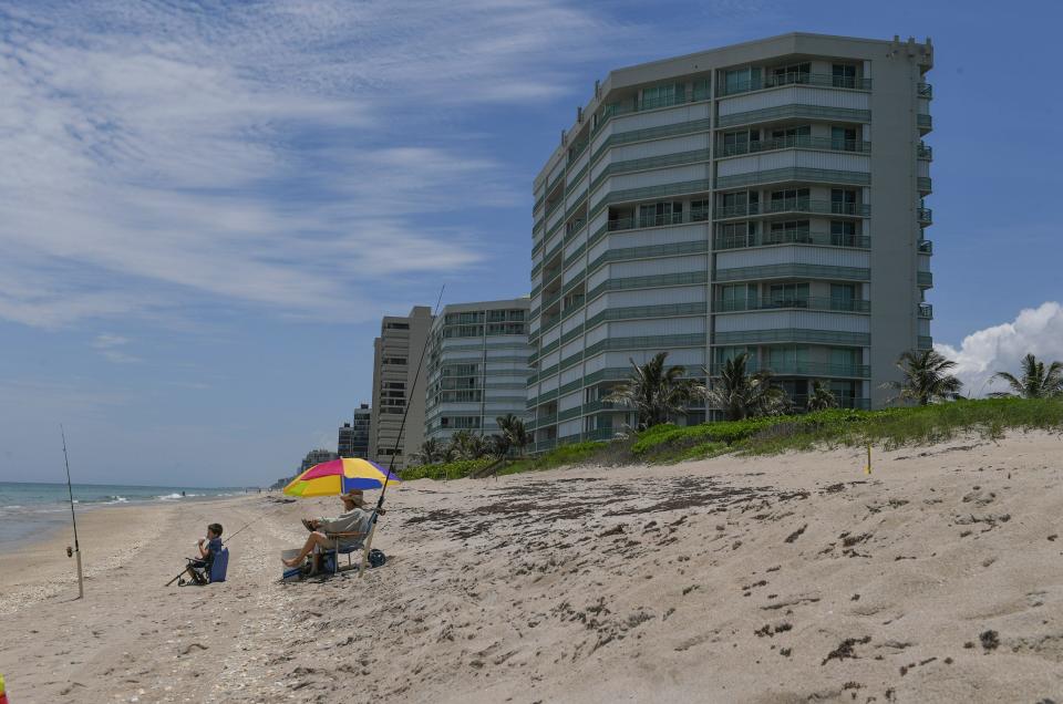 Charlie Watson, of Port St. Lucie, spends some time with his grandson Jason Maxwell, 6, as they fish off the shoreline of Normandy Beach next to the Regency Island Dunes condominium on Tuesday, June 9, 2020, in southern St. Lucie County The shoreline of Normandy Beach and a few others in southern St. Lucie County are affected by erosion issues and the county is working for ways to reduce the cost of a beach renourishment project.