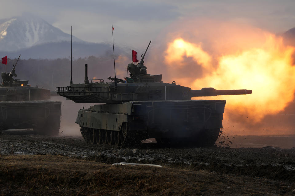 FILE - Japanese Ground-Self Defense Force (JGDDF) Type 90 tank fires its gun at a target during an annual drill exercise at the Minami Eniwa Camp in Eniwa, Japan's northern island of Hokkaido on Dec. 7, 2021. Japan warned of escalating national security threats stemming from Russia’s war on Ukraine and China’s tensions with Taiwan in an annual defense paper issued Friday, July 22, 2022, as Japan tries to bolster its military capability and spending. (AP Photo/Eugene Hoshiko, File)