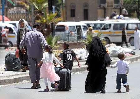 A displaced family with luggage flee from an airstrike on an army weapons depot in Yemen's capital Sanaa May 12, 2015. REUTERS/Mohamed al-Sayaghi