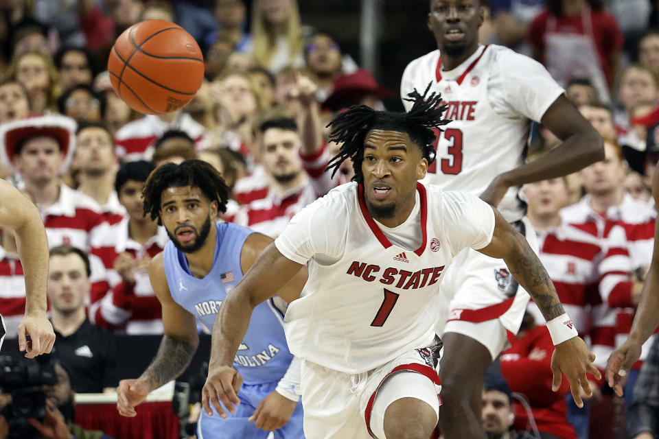 North Carolina State's Jayden Taylor (1) chases a loose ball as North Carolina's RJ Davis (4) looks on during the second half of an NCAA college basketball game in Raleigh, N.C., Wednesday, Jan. 10, 2024. (AP Photo/Karl B DeBlaker)