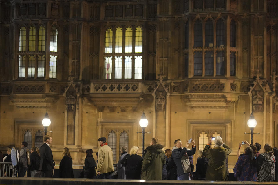 People arrive in the queue outside Westminster Palace to pay their respect to Queen Elizabeth II during the Lying-in State, at Westminster Hall in London, Thursday, Sept. 15, 2022. The Queen will lie in state in Westminster Hall for four full days before her funeral on Monday Sept. 19. (AP Photo/Markus Schreiber)