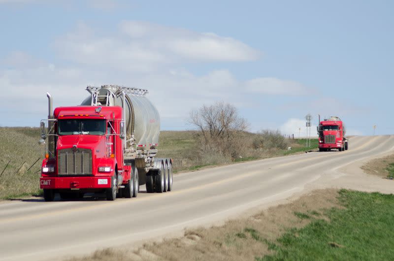 Halliburton oil trucks drive near the company's yard in Williston