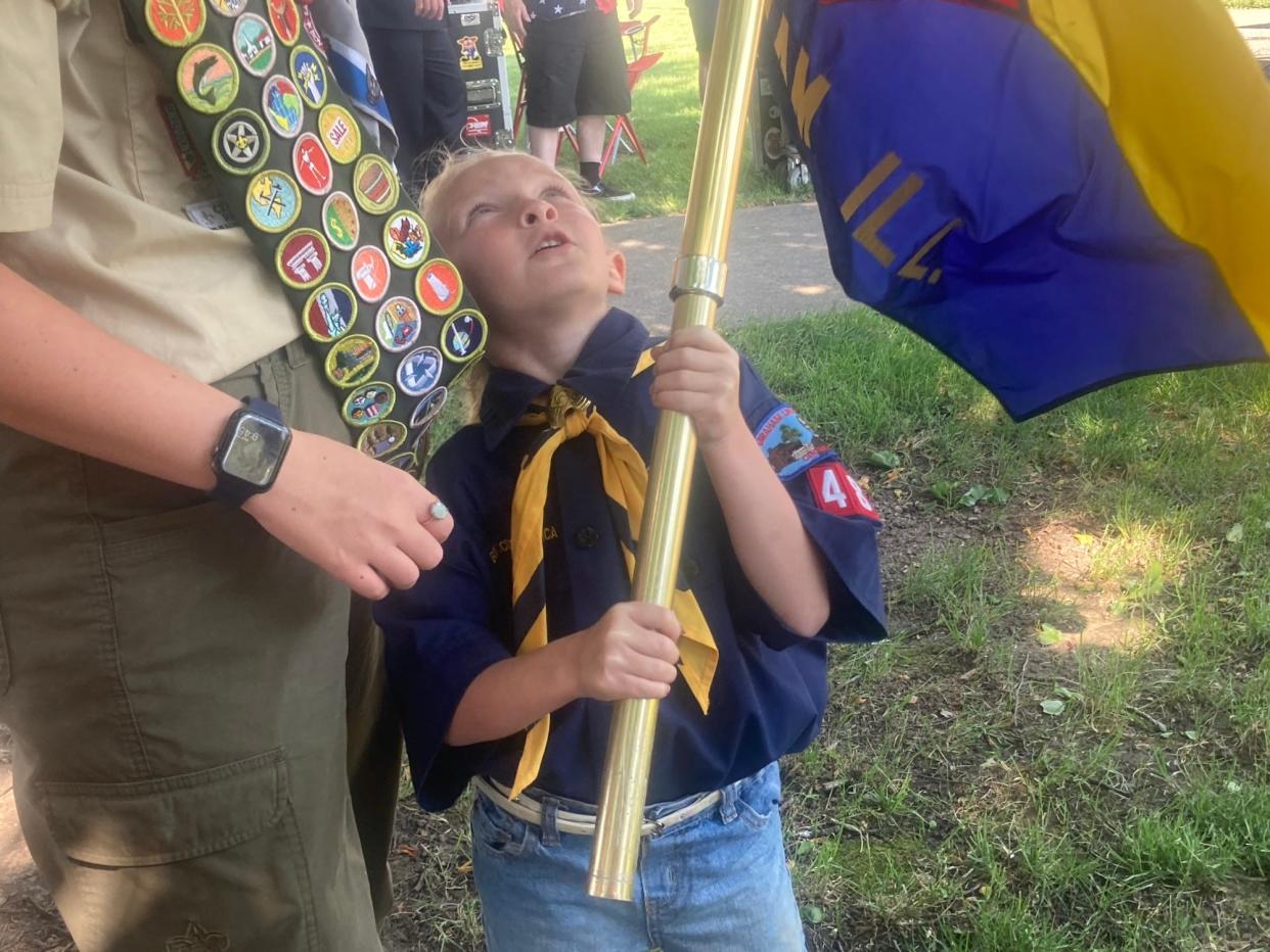 Izzy Luttrell, 6, of Boy Scout Cub Pack 48 holds the pack's flag before the beginning of a Memorial Day ceremony at Veterans Memorial Park in Chatham put on by American Legion Post 759.