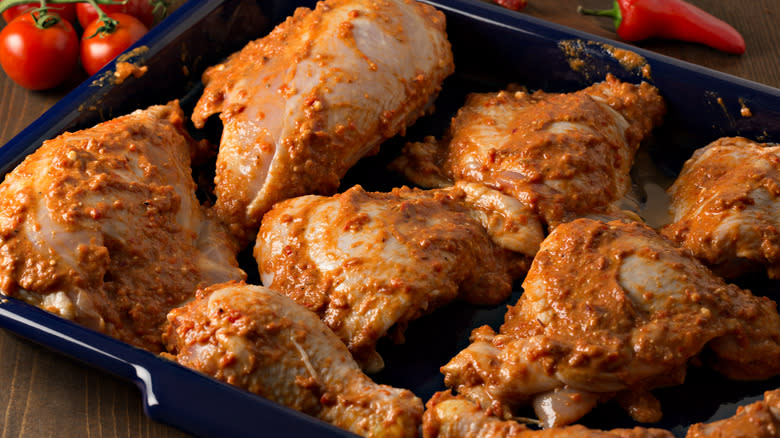 chicken marinating in a baking dish 