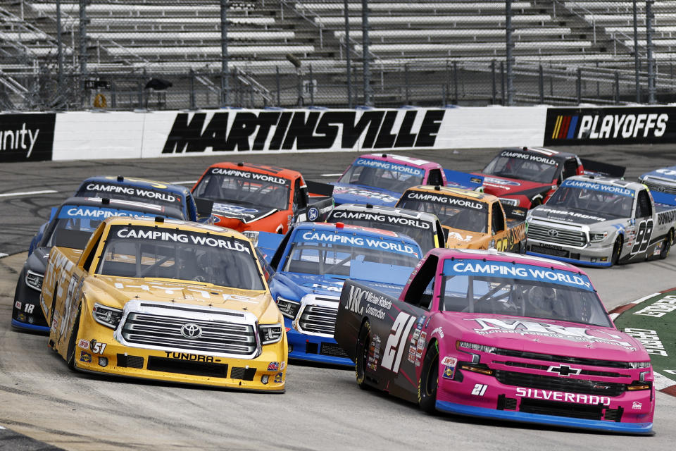 Driver Zane Smith (21) leads Corey Heim (51) and the rest of the field on a restart during the NASCAR Truck Series race on Saturday, Oct. 30, 2021, in Martinsville, Va. (AP Photo/Wade Payne)