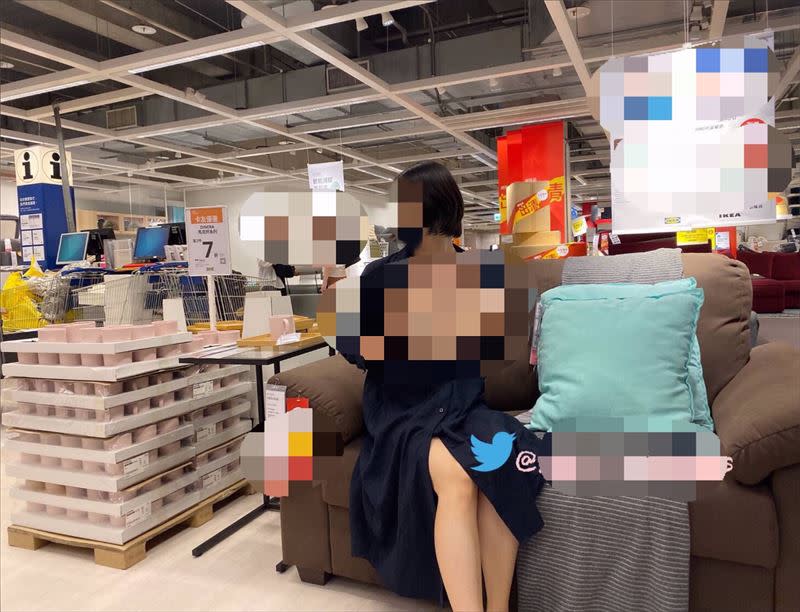 女子在沙發區敞開衣服裸露，背景竟還有民眾正在逛賣場。（圖／翻攝自推特）