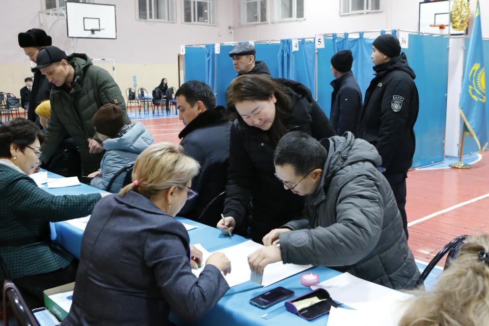 Voters get their ballots at a polling station in Astana, Kazakhstan, Sunday, Nov. 20, 2022. Kazakhstan's president appears certain to win a new term against little-known challengers in a snap election on Sunday. Five candidates are on the ballot against President Kassym-Jomart Tokayev, who faced a bloody outburst of unrest early this year and then moved to marginalize some of the Central Asian country's longtime powerful figures. (AP Photo/Stanislav Filippov)