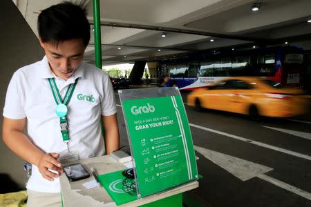 A Grab employee uses the Apps to book a cab for passengers at the Ninoy Aquino International Airport (NAIA) in the metro Manila, Philippines, July 22, 2016. REUTERS/Romeo Ranoco