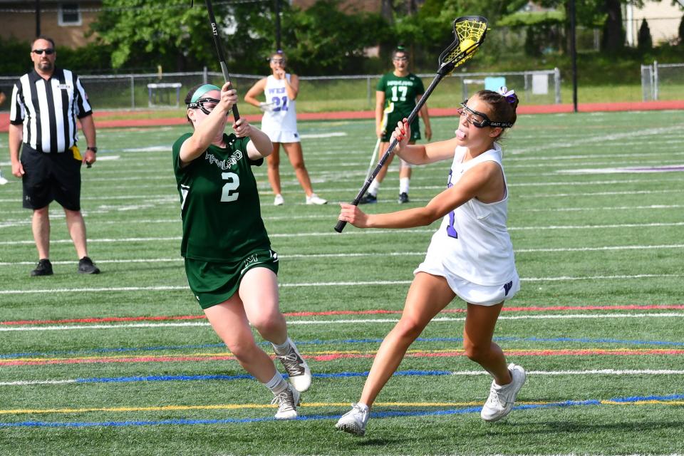 Cherry Hill West freshman Tatum Woods slides a shto by Mainland sophomore Lynn McLaughlin