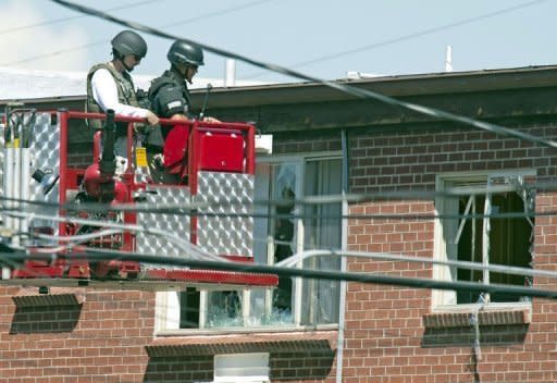 Law enforcement officers prepare to place an explosive device inside the appartment of shooting suspect James Holmes in Aurora, Colorado. Police believe they have defused the "remaining major threats" in alleged Batman gunman James Holmes's booby-trapped apartment, they said Saturday, adding that the devices were designed to kill