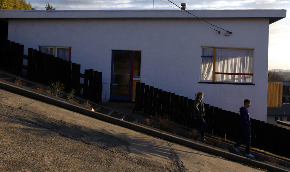 Two people walk down Baldwin street in Dunedin, September 5, 2011. Baldwin street is considered as one of the world's steepest streets.   REUTERS/Marcos Brindicci (NEW ZEALAND - Tags: SOCIETY TRAVEL)