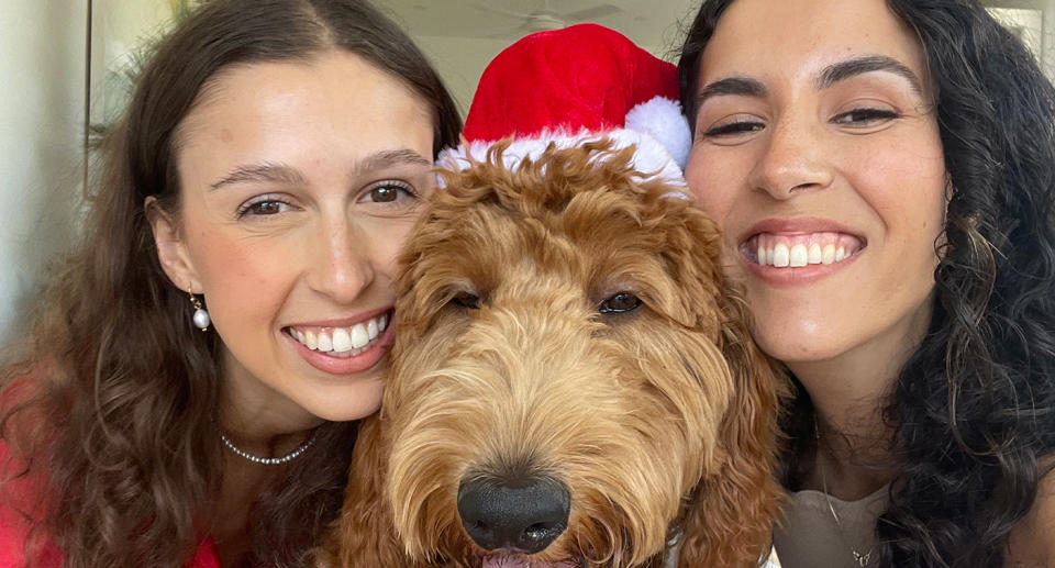 Grace Thadani and Kirra Graham with dog in Santa hat