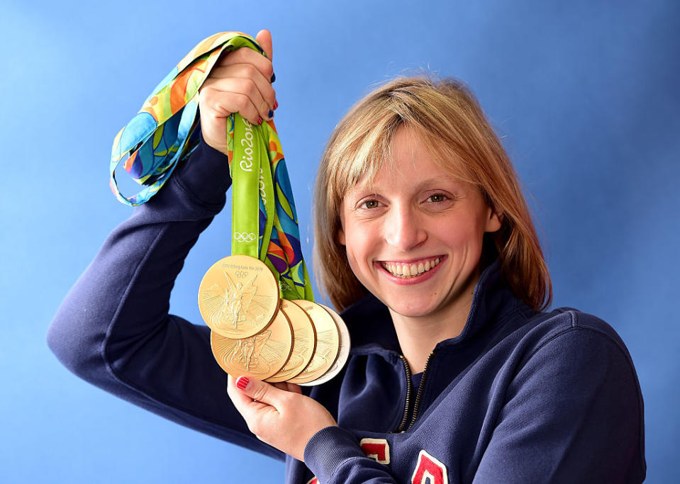 Katie Ledecky has so many olympic medals that she actually needed help holding them at a baseball game