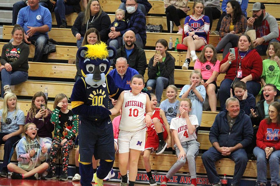 Members of the Lady Artesians youth basketball league react to Aden Cross getting picked to do a trick with Boomer during halftime of Tuesday's Martinsville girls' basketball home game against Center Grove.