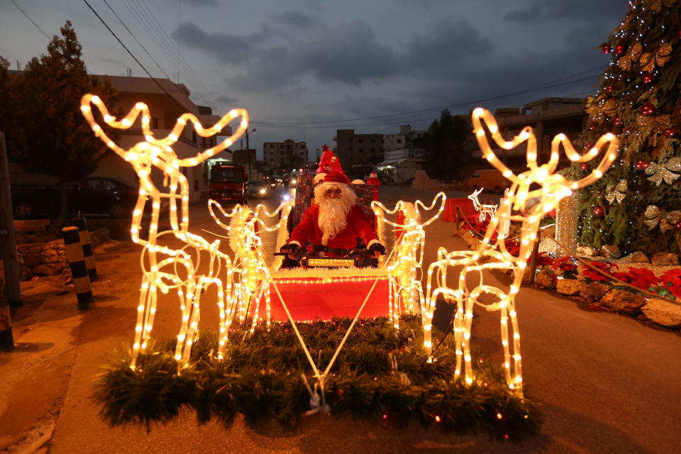 A man dressed as Santa Claus rides a decorated vehicle in Jiyeh, Lebanon