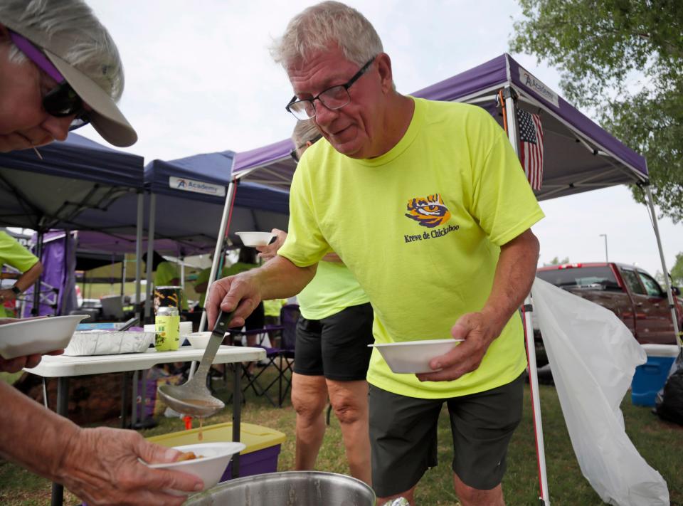 LSU fan Thomas Loupe dishes out food to Alice Fontenot during a tailgate before Thursday's Women's College World Series opener at USA Softball Hall of Fame Stadium.