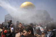 Muslim worshippers are sprayed with cool water during Friday prayers for the Muslim holy month of Ramadan at the Dome of the Rock Mosque in the Al Aqsa Mosque compound in the Old City of Jerusalem, Friday, April 30, 2021. (AP Photo/Mahmoud Illean)