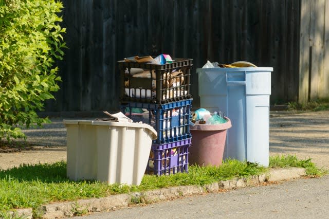 Bins of comingled recycling wait on curbside for pickup.